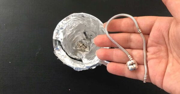 Una ciotola con alluminio e sale lucida ciondoli e braccialetti d’argento