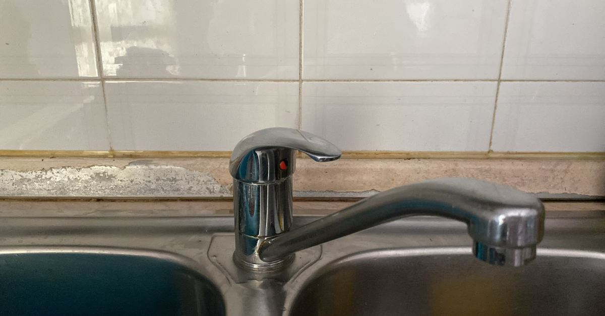 La zona dietro il rubinetto della cucina diventa scura prima del resto del lavello La zona dietro il rubinetto della cucina diventa scura prima del resto del lavello